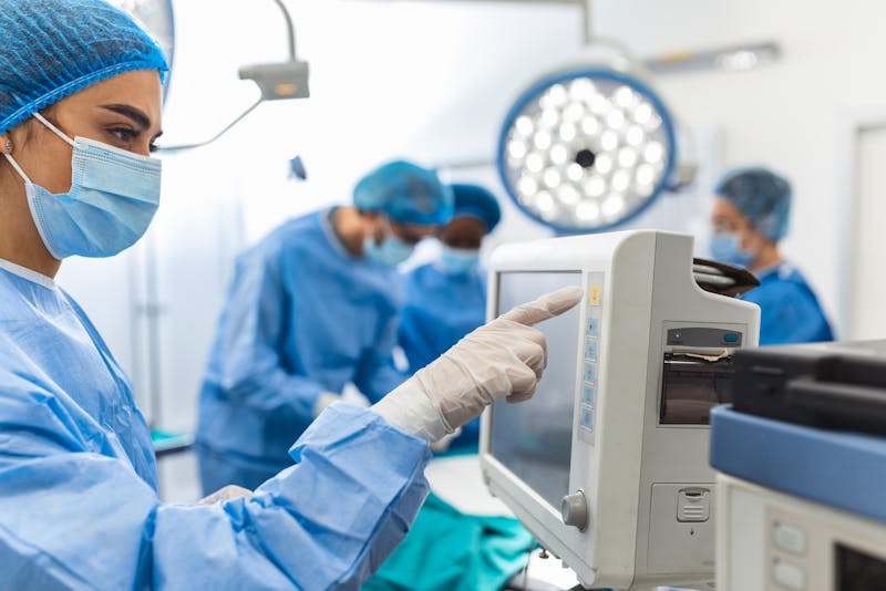 surgeons in a operating room looking at a moniter