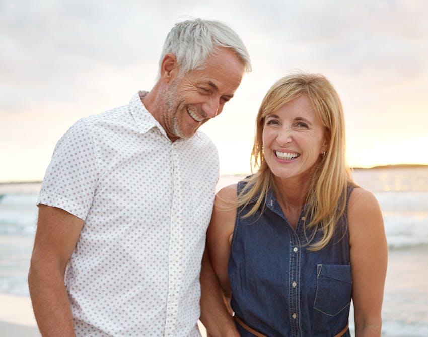 Middle-aged man and woman walking along the beach