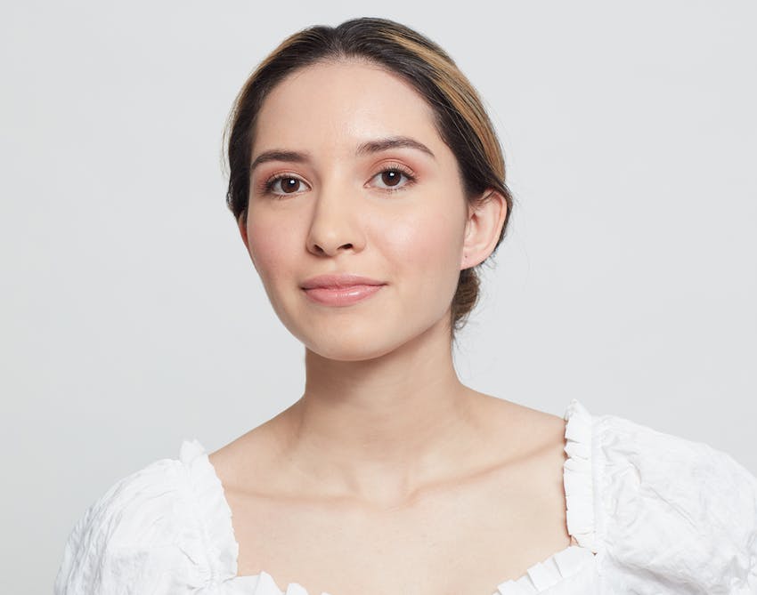Woman in a white top with her hair pulled back