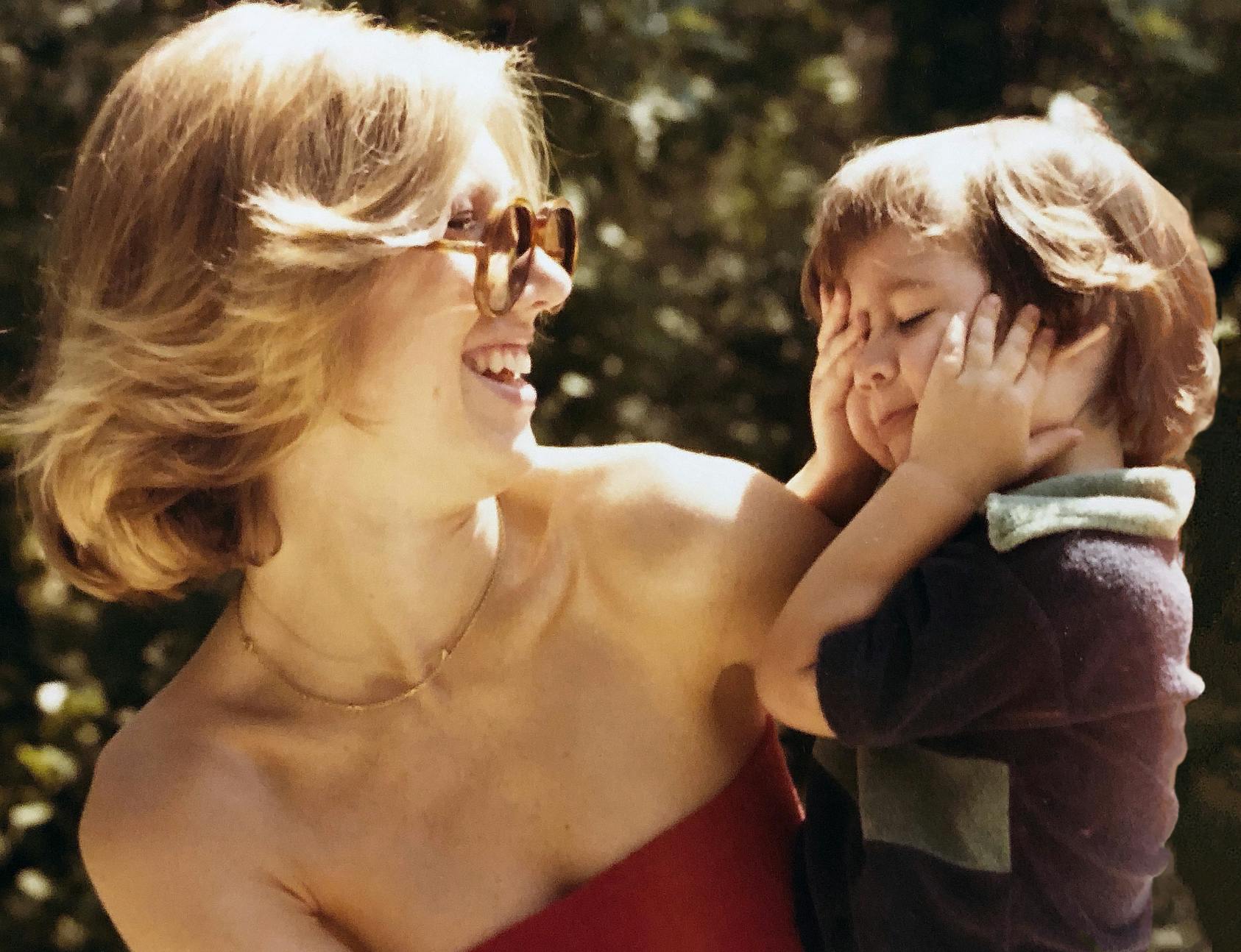 Blonde woman smiling and holding her son