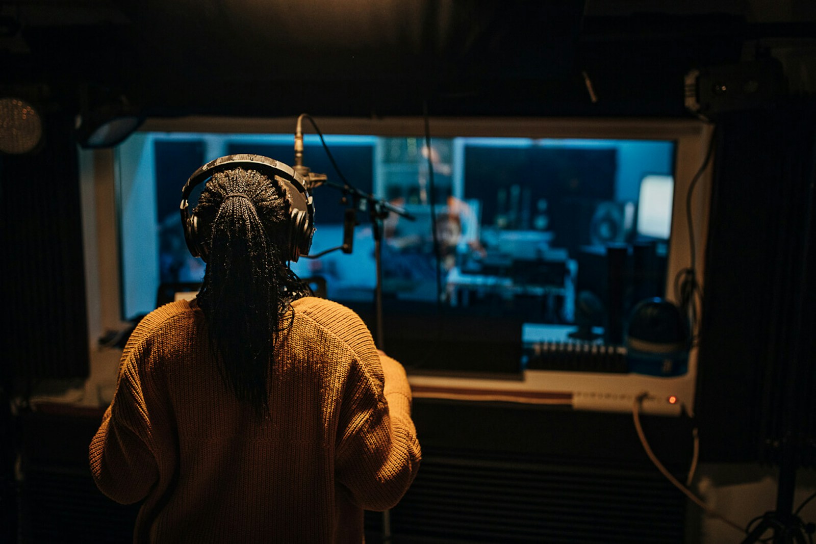 Vocalist Sings in a Recording Booth in a Music Studio