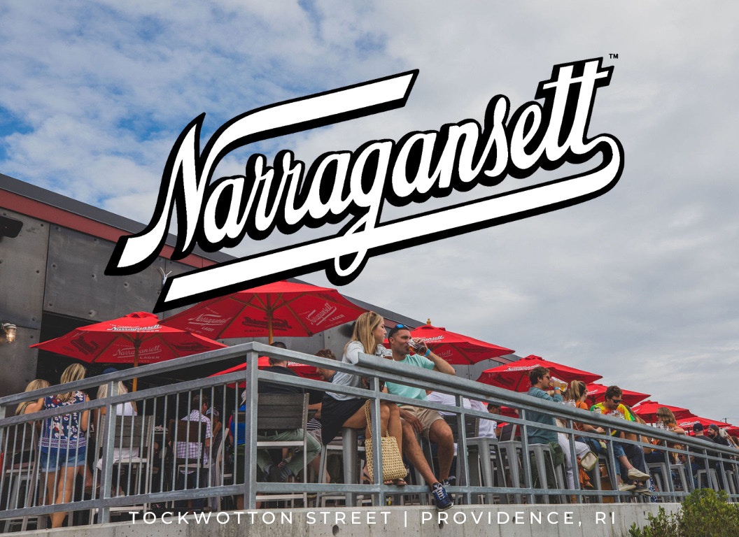 People enjoying drinks on an outdoor patio with red umbrellas, featuring the Narragansett logo and location text: Tockwotton Street, Providence, RI.