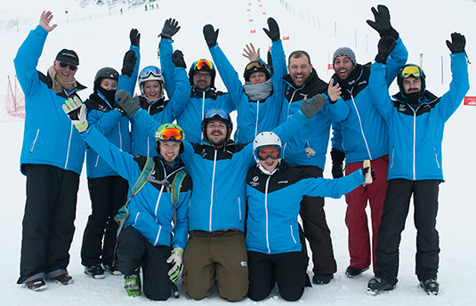 Group of ski professionals waving