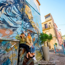 Two friends exploring the street art on show at Sete's MACO open-air street art museum