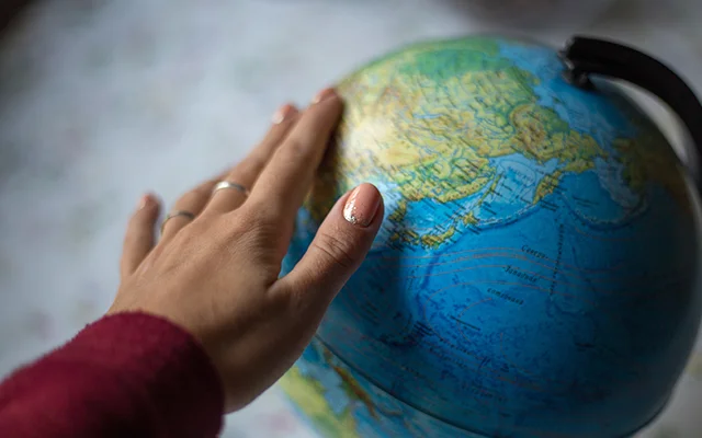 A hand on a globe