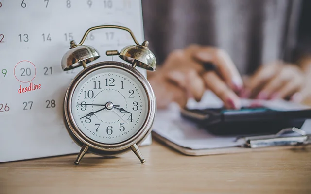Alarm clock in front of a calendar