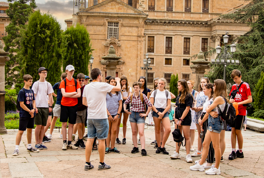 teacher addressing students infront of historic building