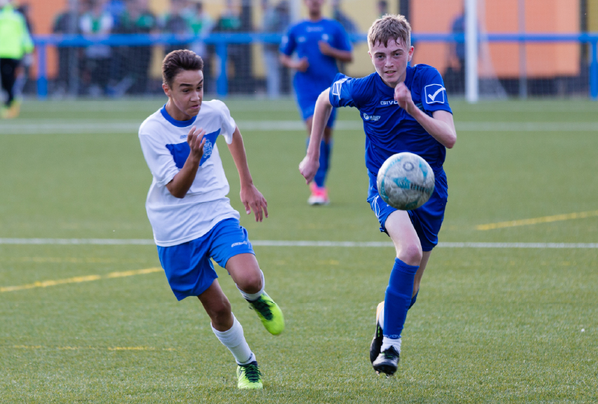 two young footballers chasing a ball
