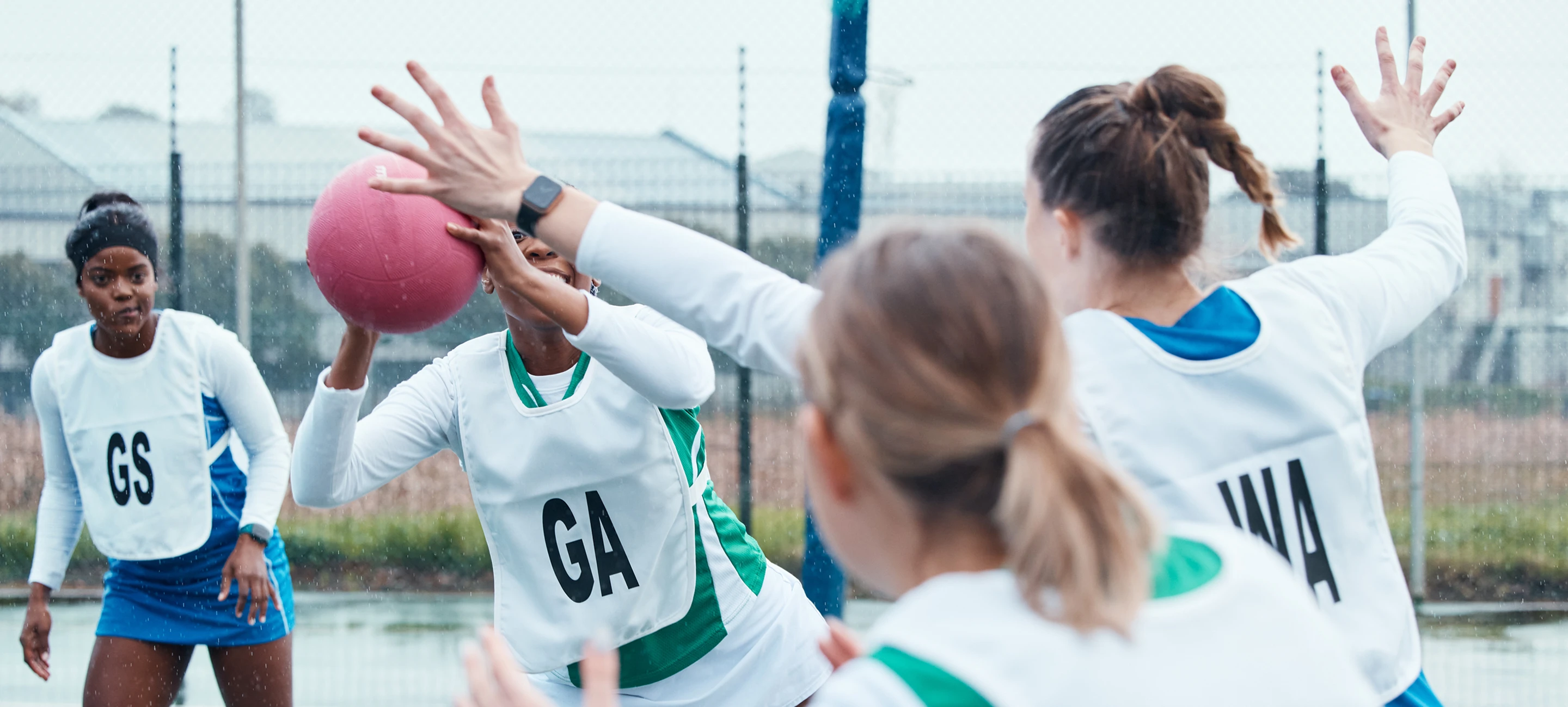Two teams of girls playing netball