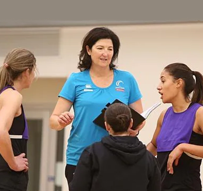 Netball coach showing game plan to students