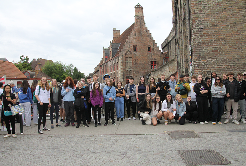 A group of students stand on a bridge in Bruges