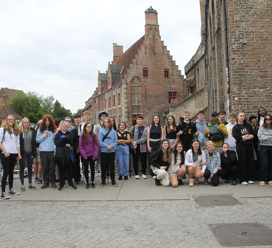 A group of students stand on a bridge in Bruges