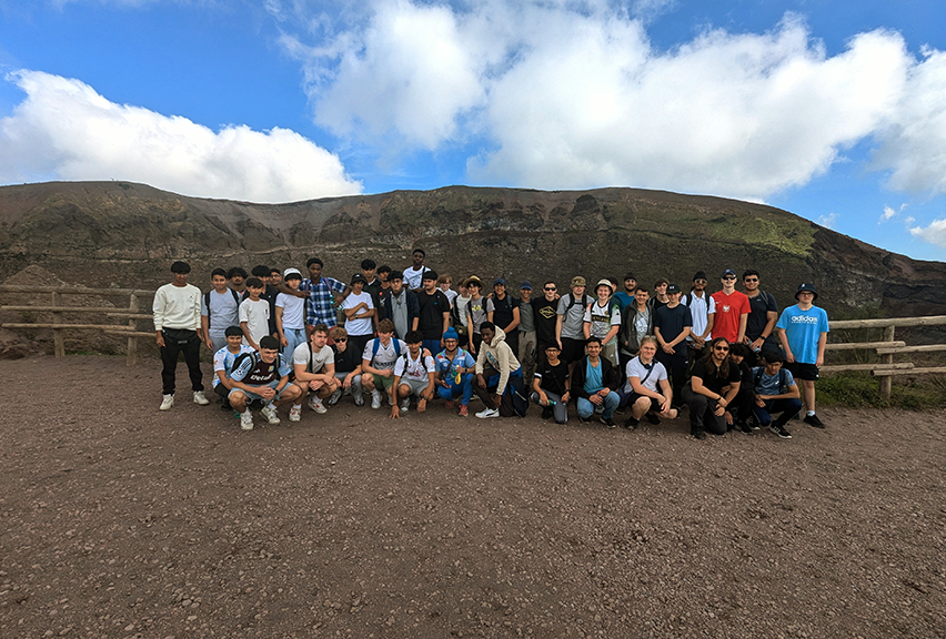 A group of students standing in front of Mount Vesuvius crater