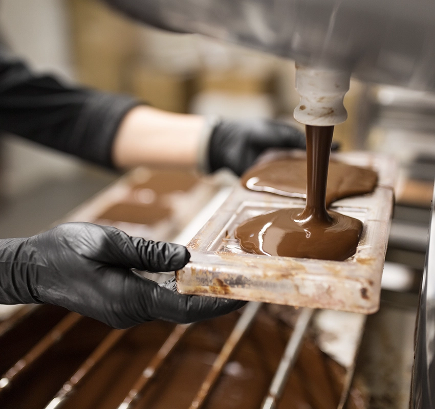 Chocolate being poured into molds at a chocolate factory