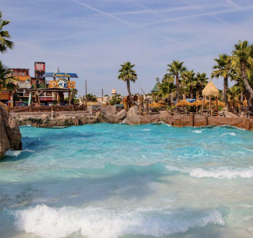 Blue choppy waters surrounded by palm trees inside Caribe Bay Water Park