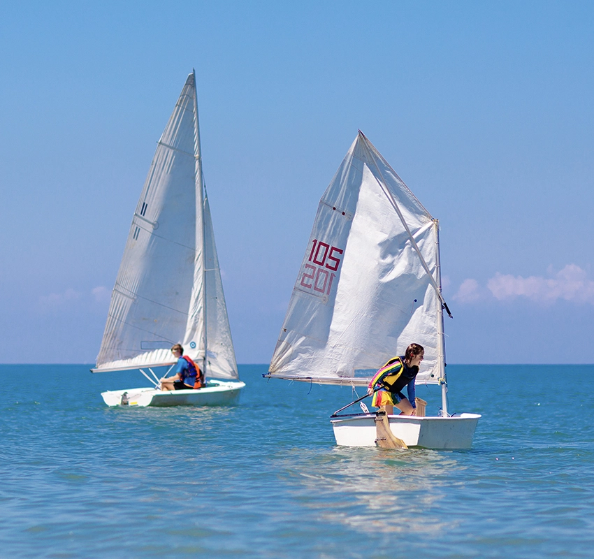 Two people on sailboats in the sea