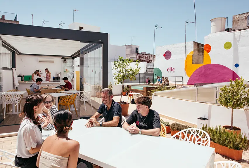 students and teachers sat around a table on a rooftop