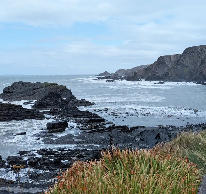 Waves crashing onto black rocks at devonshire beach