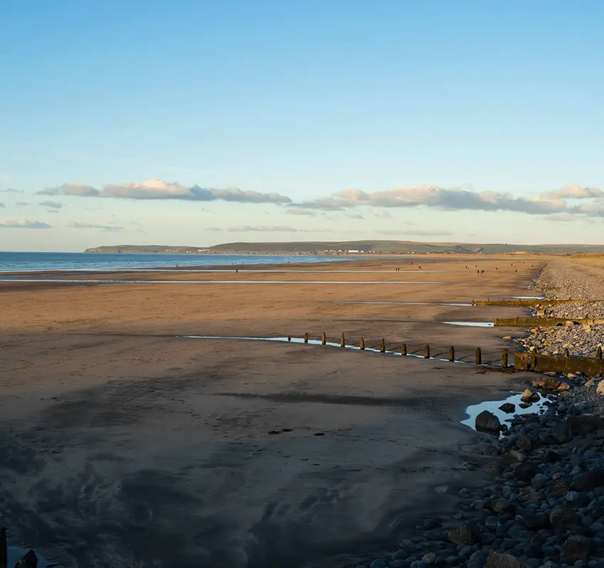 Long view of clear sandy beach under a blue sky