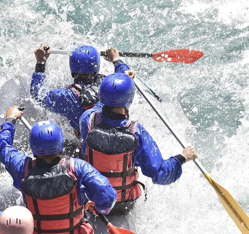 Rafting team tackling a wave