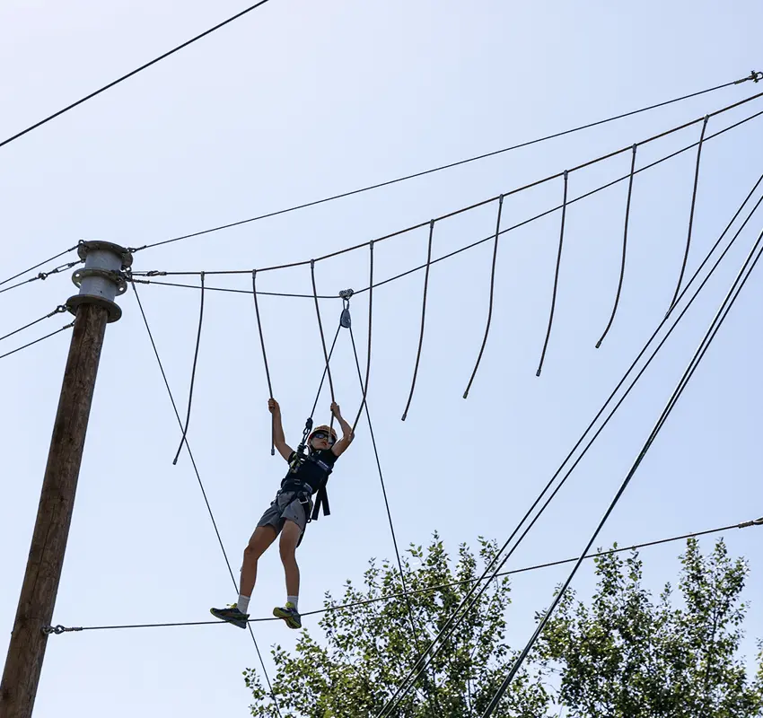 Young child balances on high ropes