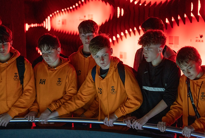 A School Group in the LAVA Centre Iceland A group of students wearing orange hoodies, collected around a display in the LAVA Centre, Iceland
