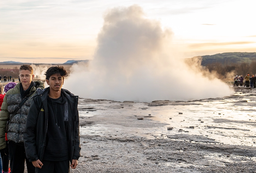 A school group at the Great Geysir in Iceland Two boys stand in front of an erupting geysir in Iceland