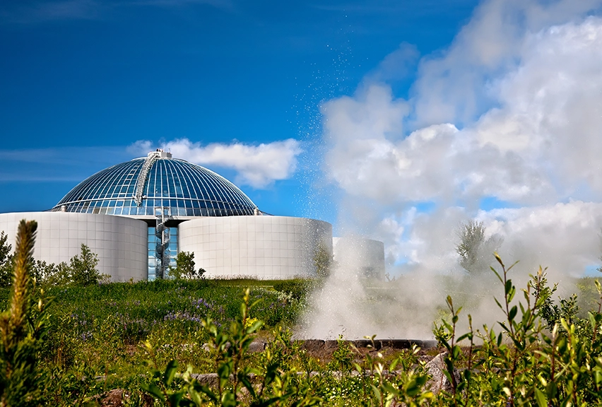 The Perlan Museum Landscape view of the Perlan Museum in Iceland, with a geysir erupting in the foreground