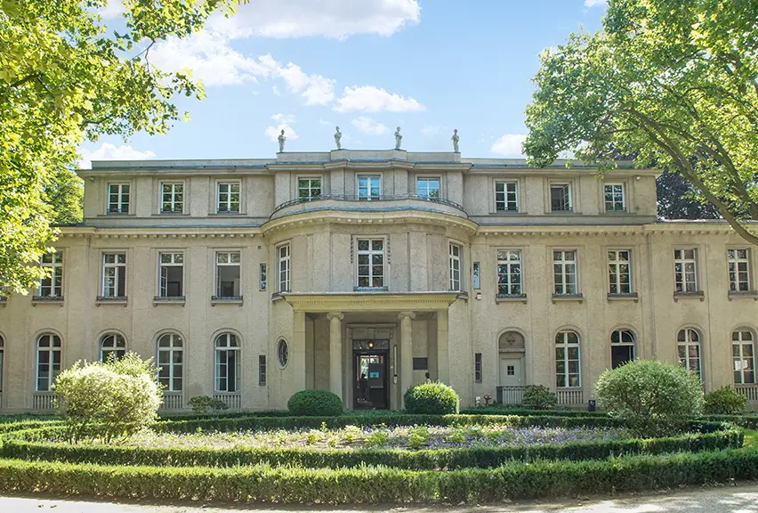 House of the Wannsee Conference The front of a mansion-like buidling, set amongst trees and shrubbery