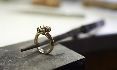 white gold ring in the foreground in the process of setting