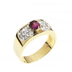 Close-up on a white background of a yellow gold ring with rubies and brilliant-cut diamonds