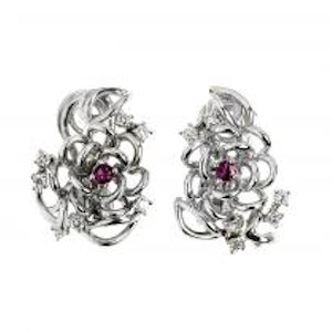 Close-up on a white background of white gold earrings with rubies and brilliant-cut diamonds