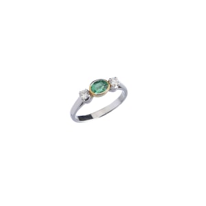 Gold ring with emerald on a white background