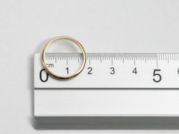 Biscioni Gioielli ring leaning on a ruler to take the correct measurement on a white background