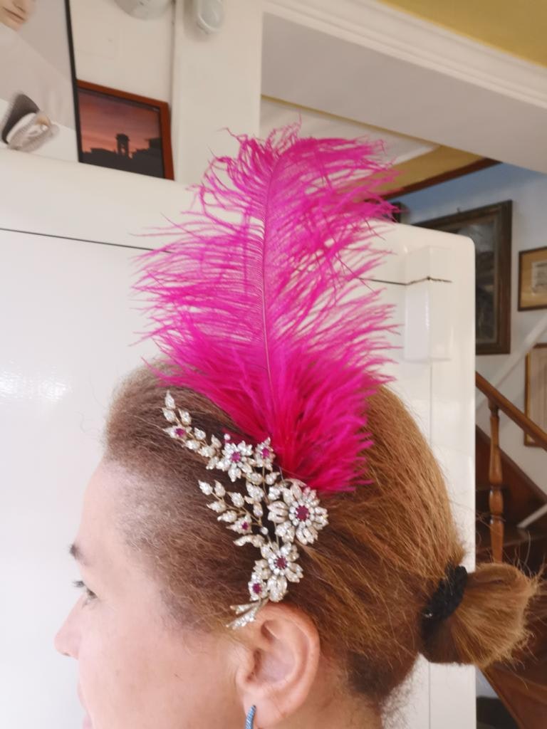 Giuditta Biscioni is wearing a brooch of her own production in her hair with a feather