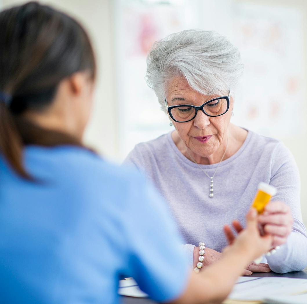Doctor handing a woman a pill bottle