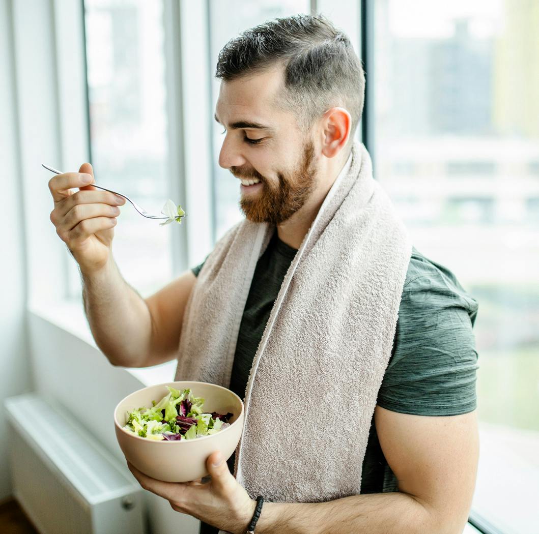 Man eating a bowl of salad