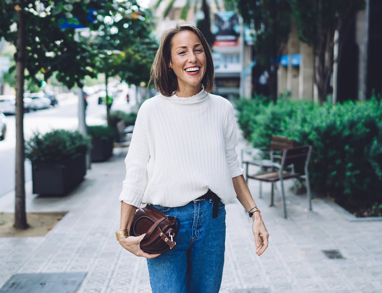 Woman with a purse standing on the sidewalk