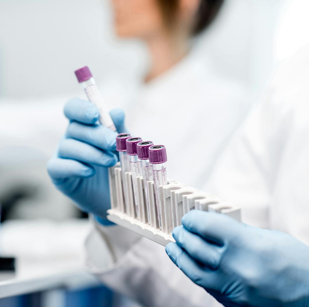 Medical personnel loading vials into a holder.