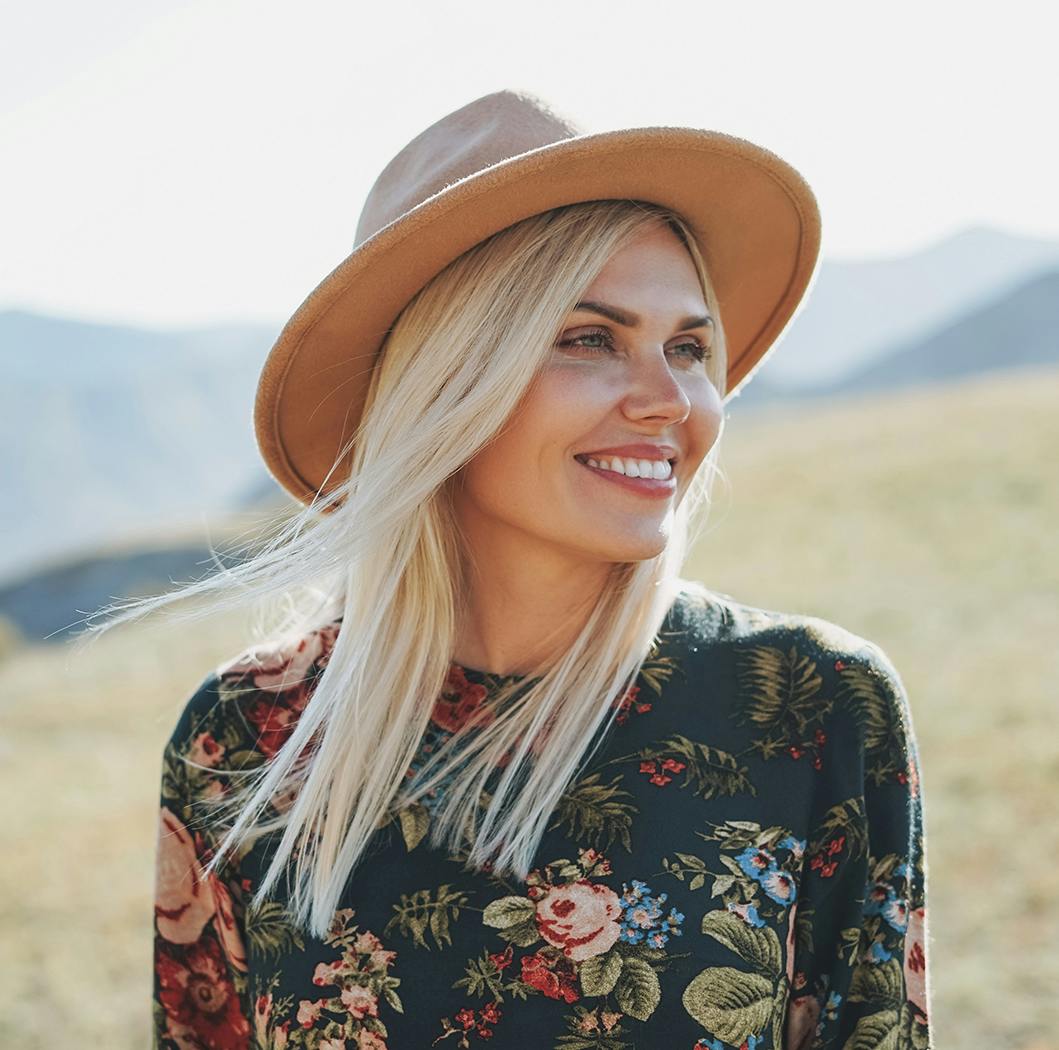 Blonde woman in a large hat smiling
