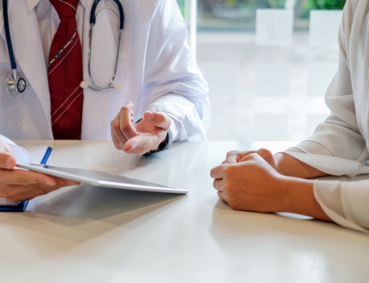 Doctor with an ipad sitting next to a woman