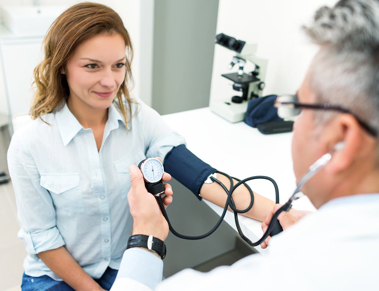 Doctor checking womans blood pressure
