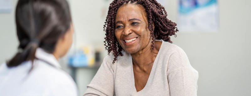 Woman smiling and talking to another woman.