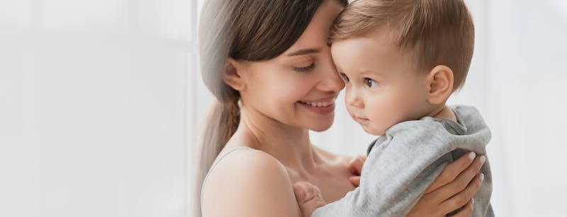 Woman smiling and holding a small child.