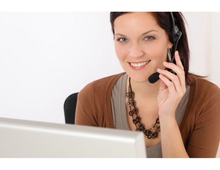 Woman talking on the phone in front of a computer