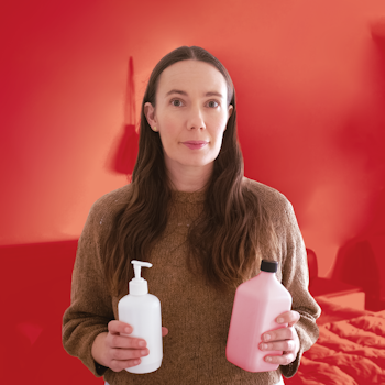 Woman holding bottles of cosmetics.
