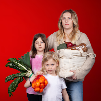 Photo of family holding groceries on red background.