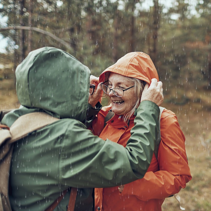 Old women in rainy forest smiling