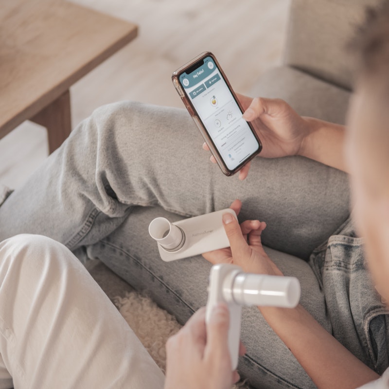 Two People Using Asthma Tuner In Couch