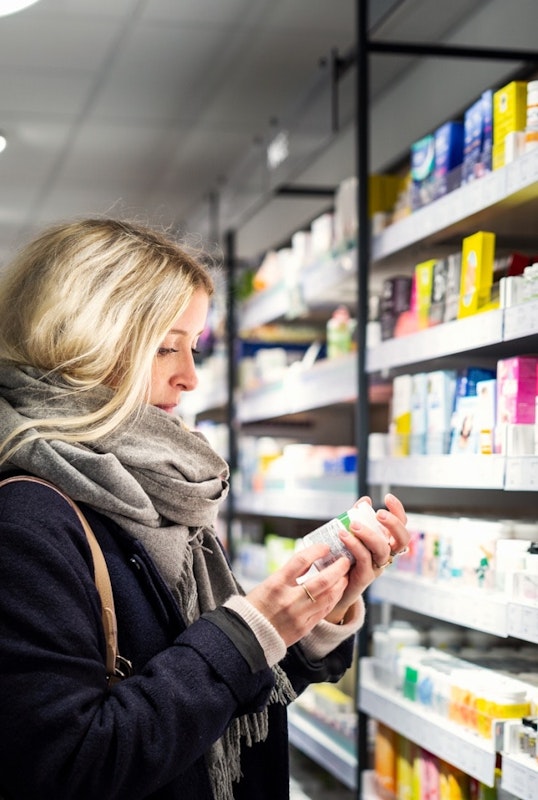 Woman In Drug Store Looking At Item